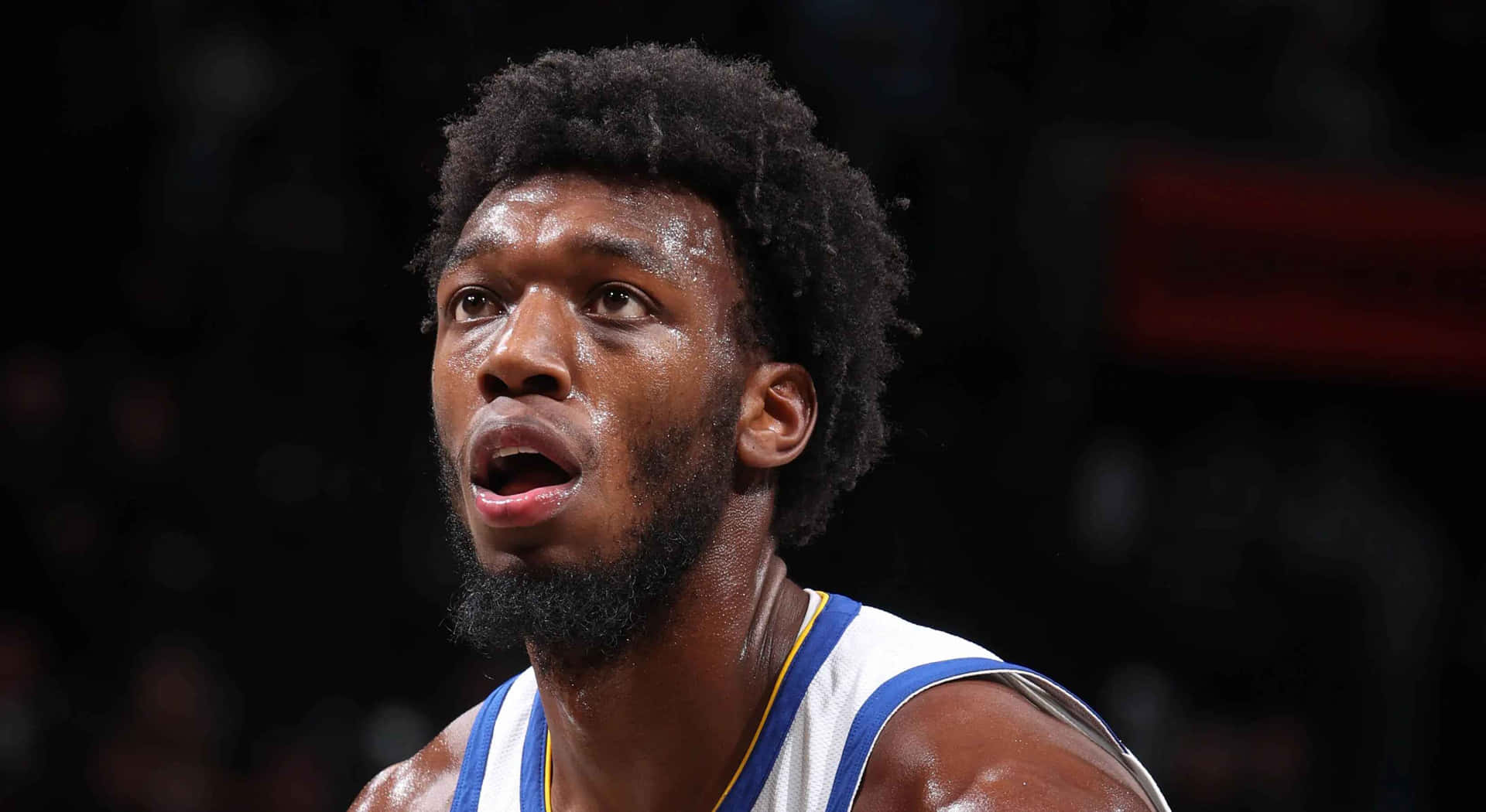 一位汗流浹背的籃球運動員在比賽中向上看的特寫。 — NBA 壁紙