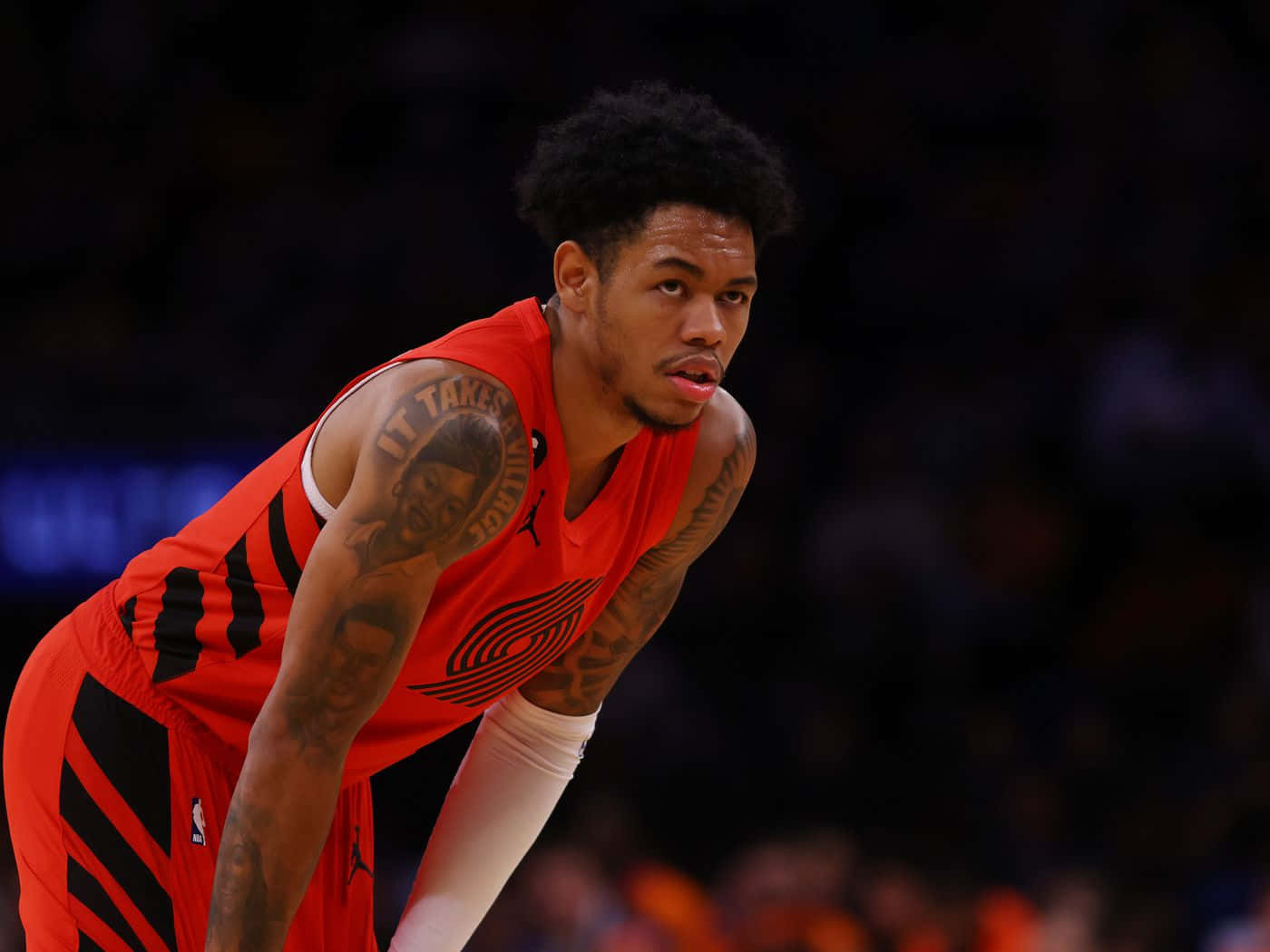 身穿紅色球衣的籃球運動員在比賽期間向前傾 — NBA 壁紙