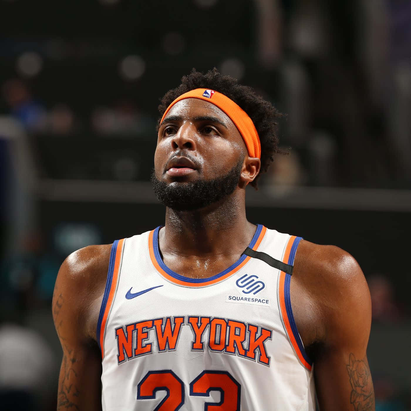 身穿紐約尼克隊球衣的籃球運動員在比賽時向上看。 — NBA 壁紙