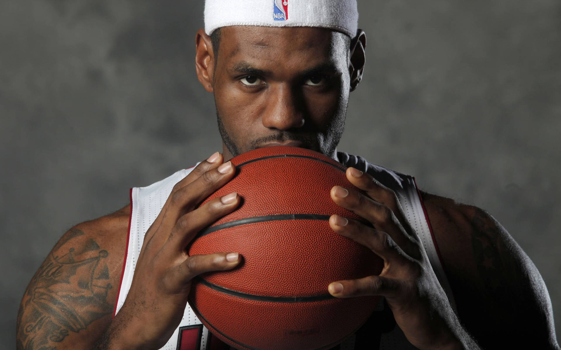 職業籃球運動員在工作室中以強烈眼神持球。 — King Lebron James 壁紙