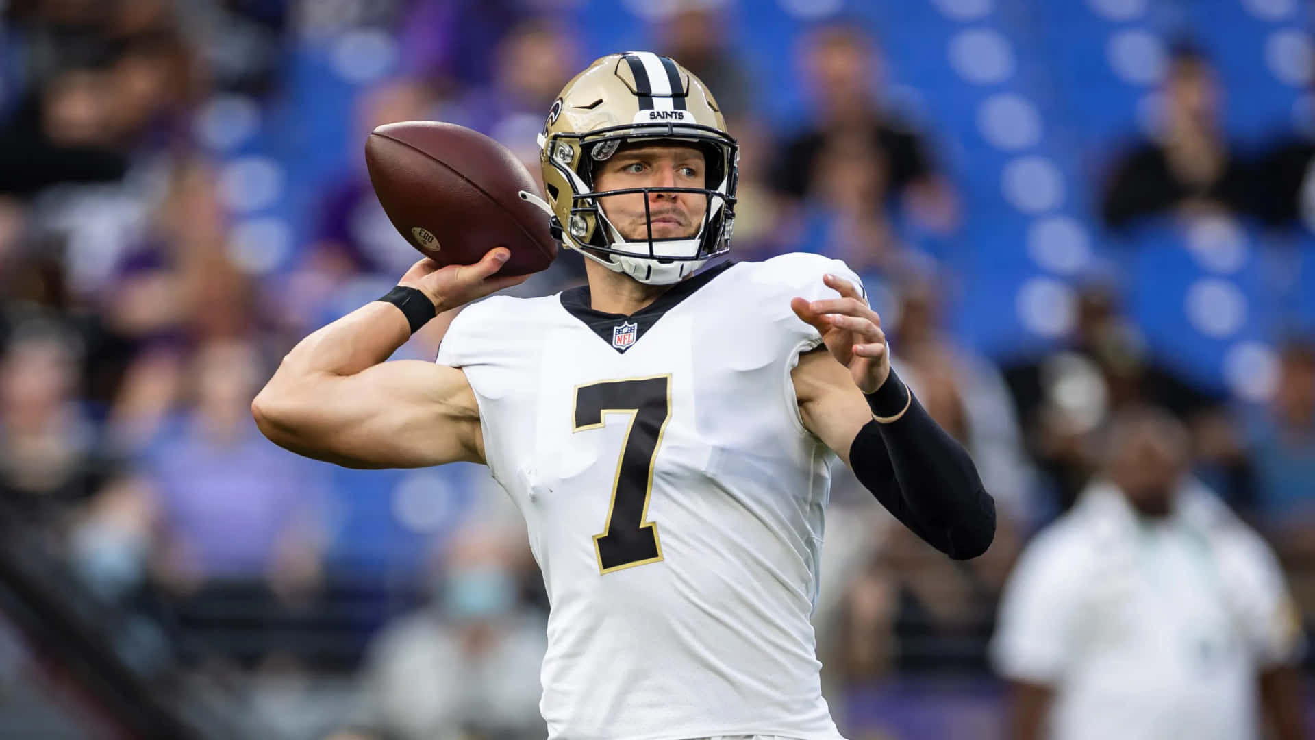  壁紙 — 一位專注的NFL四分衛身穿白色7號球衣，在日間比賽中準備擲出橄欖球。