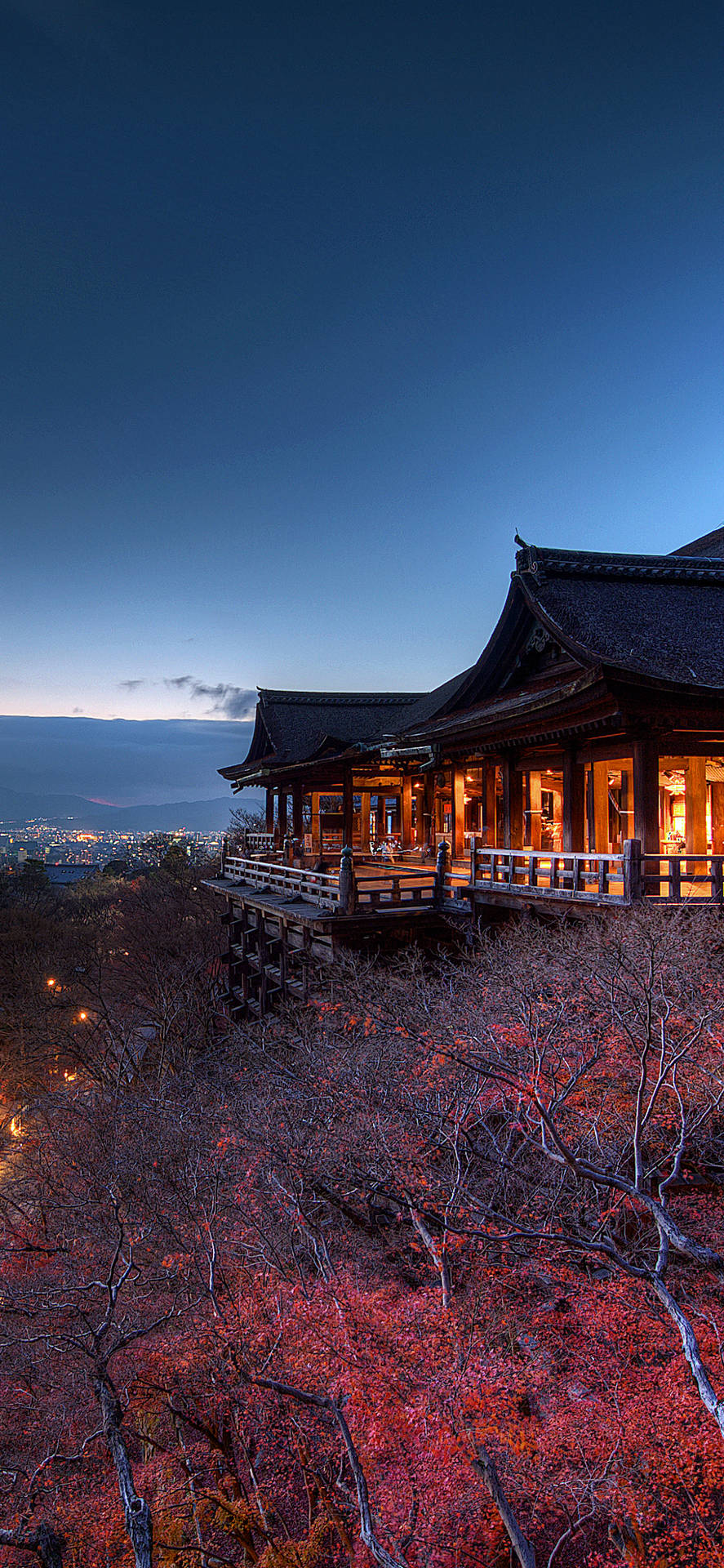 山坡上的寺廟，紅葉和城市燈光在暮色中 — iPhone 13 Pro 壁紙