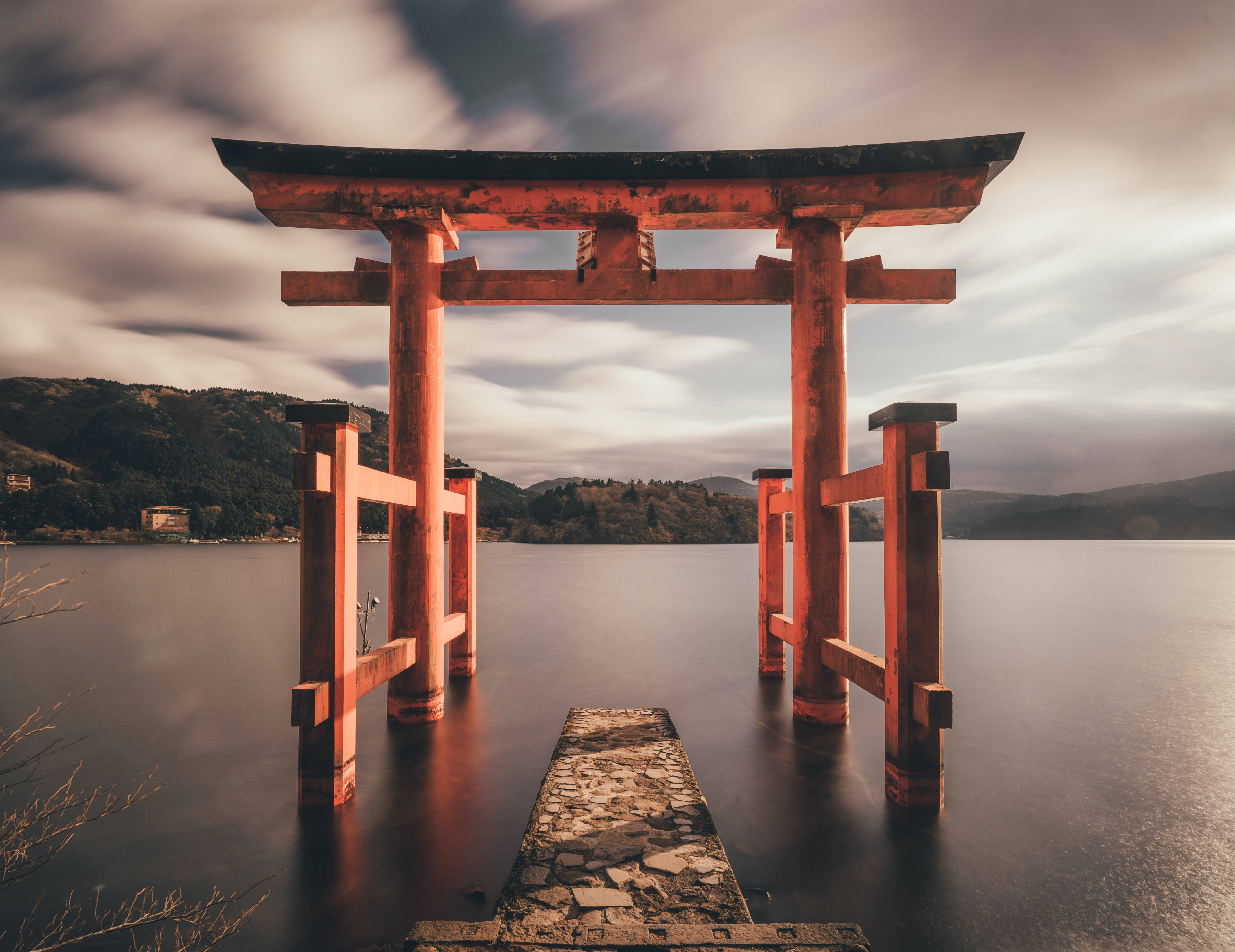 夕陽下，水中紅色鳥居與石徑，背景是山巒。 — 日式藝術 壁紙