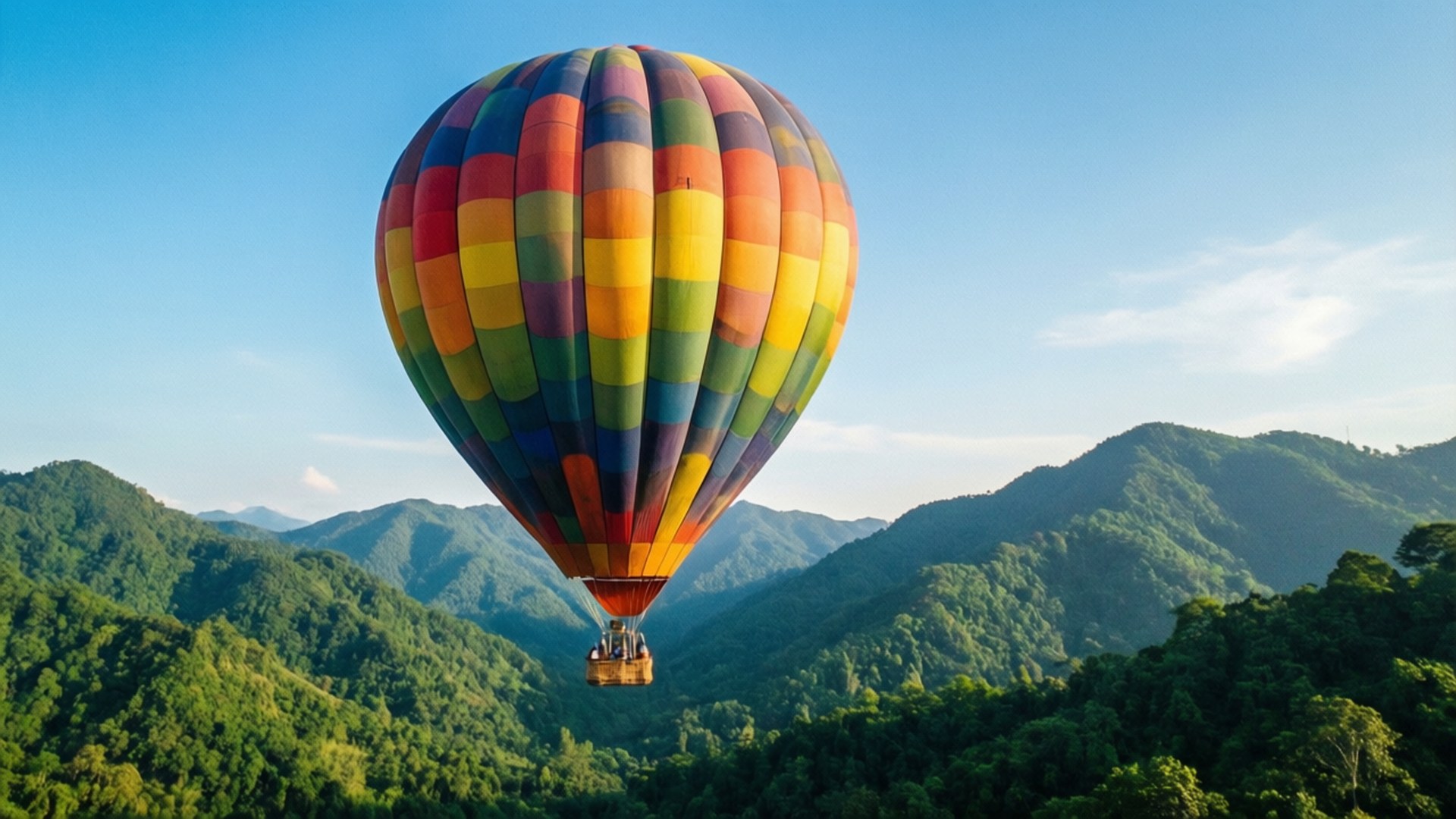 Balloon Adventure 壁紙 — 一個充滿活力的彩色熱氣球在晴朗的藍天下，寧靜地漂浮在鬱鬱蔥蔥的綠色山脈之上。