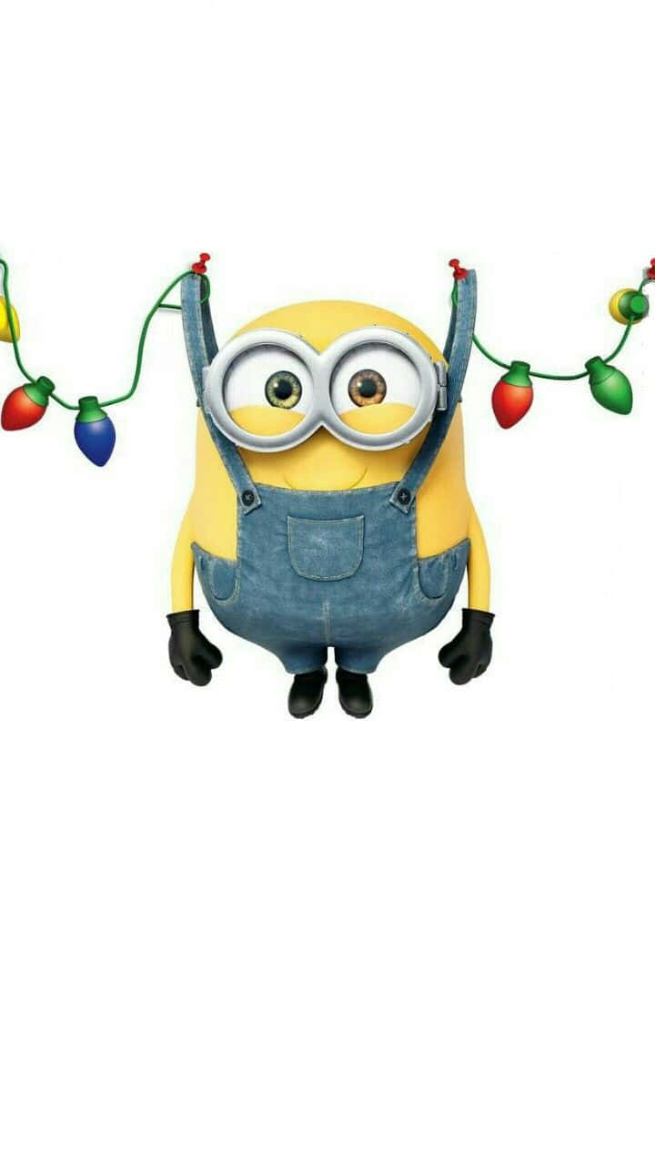  壁紙 — 一個穿著牛仔布工裝褲的開心黃色Minion，在純白色背景上拿著色彩繽紛的聖誕燈飾。