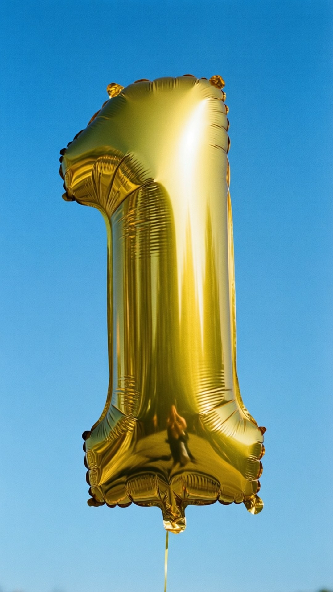 Gold Balloon Number One 壁紙 — 一個閃亮金色數字一氣球在清澈的藍天中漂浮，明亮的陽光在其表面反射。