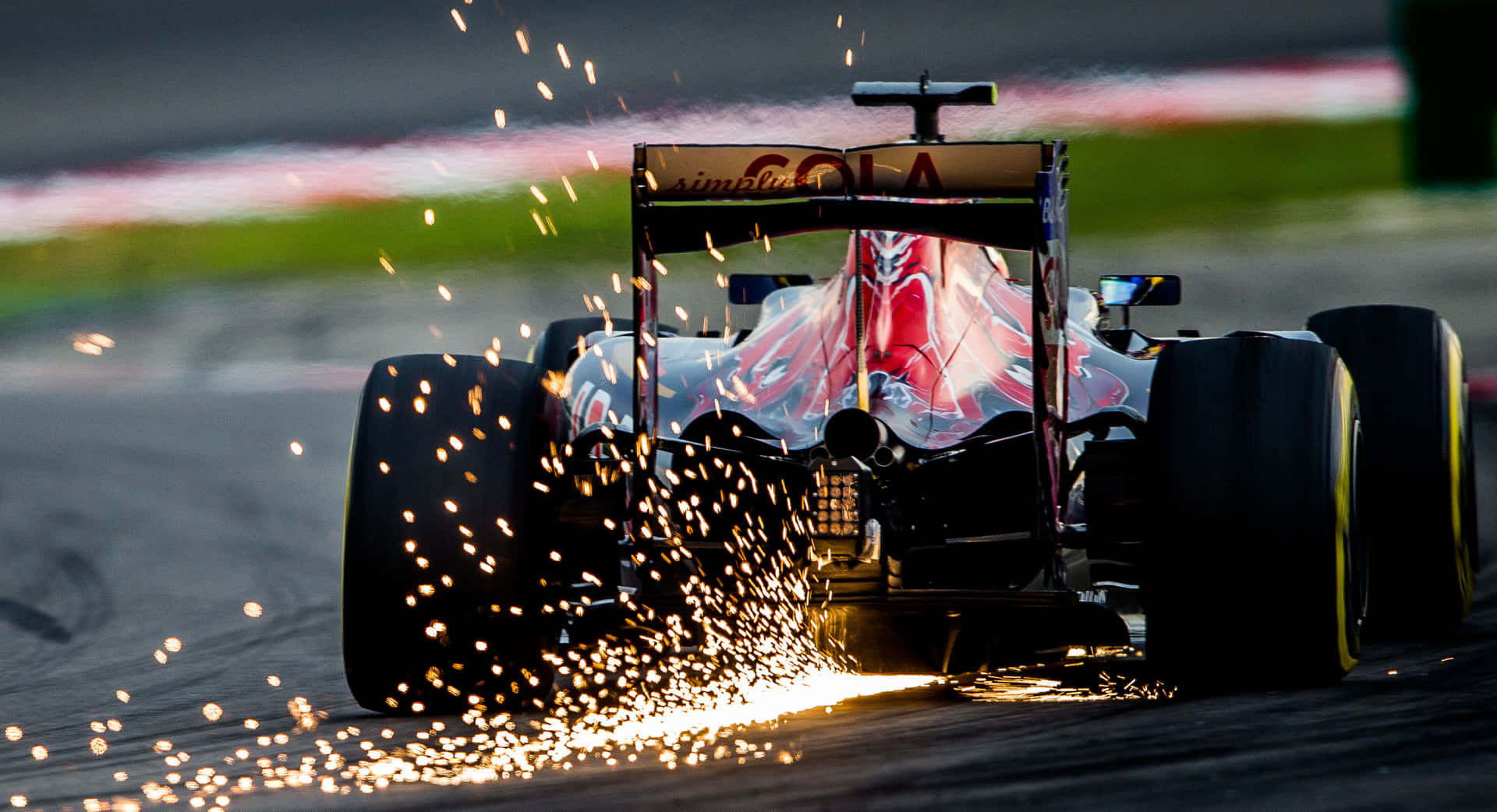 一級方程式賽車在夜間賽道上高速行駛，輪胎擦出火花。 — F1 壁紙