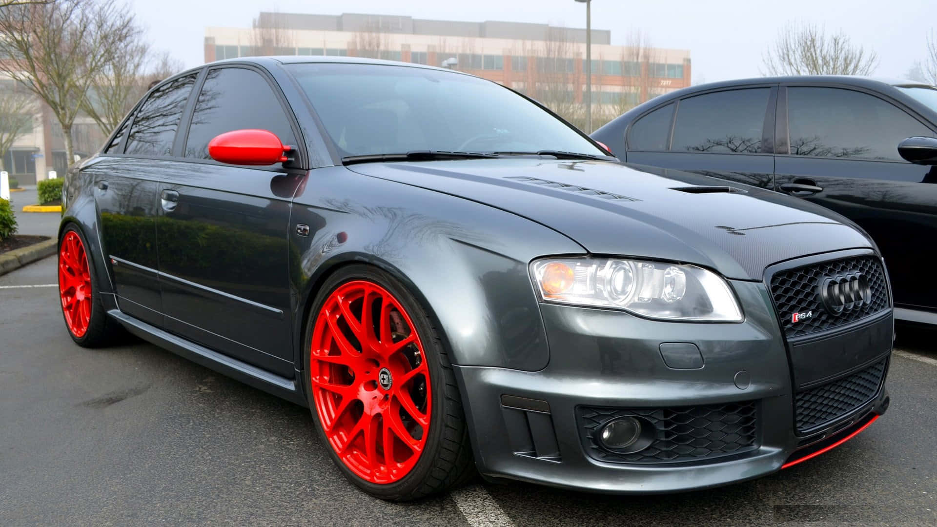 Audi Rs4 桌布 壁紙 — 一輛時尚的啞光灰色奧迪RS4，配以鮮紅色輪圈和側鏡，停泊在都市地段。