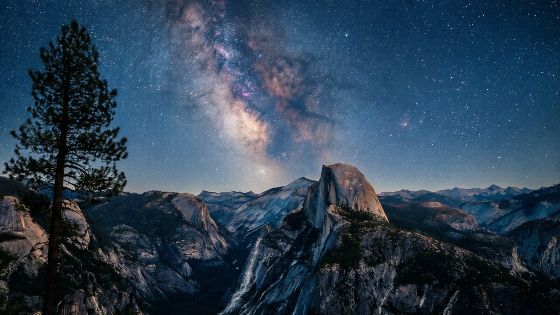 Starry Sky Glacier Point 壁紙 — 銀河系在星空下壯麗地拱起於半圓頂山上，前景有一棵孤獨的松樹。
