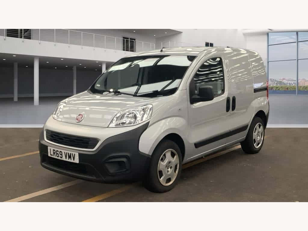  壁紙 — 一輛銀色Fiat Fiorino客貨車停放在室內，在明亮的人造燈光下，配有反光窗戶和混凝土地板。