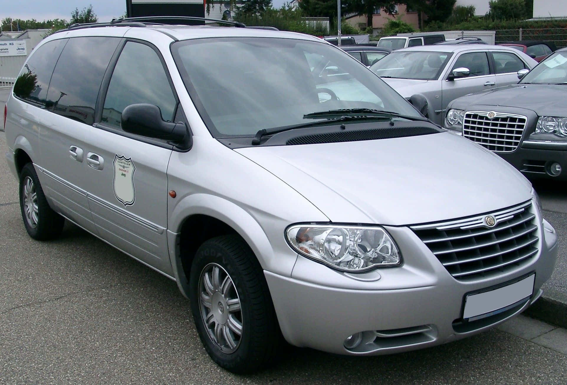 Chrysler Voyager 桌布 壁紙 — 一輛銀色警用小型貨車停放在停車場，背景可見其他車輛。
