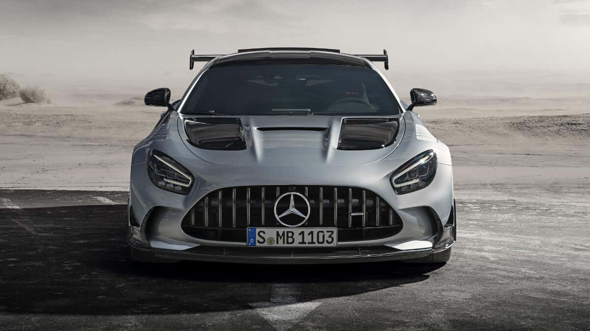 Mercedes Benz Amg Gt 桌布 壁紙 — 一輛銀色 Mercedes-AMG GT Black Series 跑車帶有後擾流板，停泊在塵土飛揚的沙漠公路上，天空朦朧。