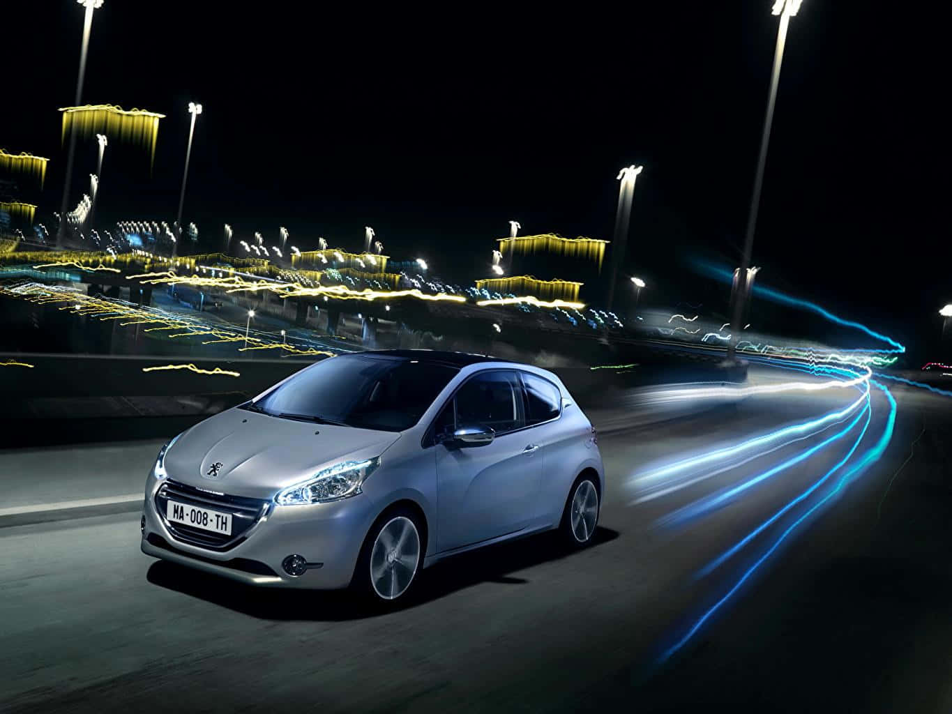 Peugeot 208 桌布 壁紙 — 一輛銀色Peugeot汽車在夜間於濕滑道路上高速行駛，背景有發光的藍色光軌和燈火通明的建築物。