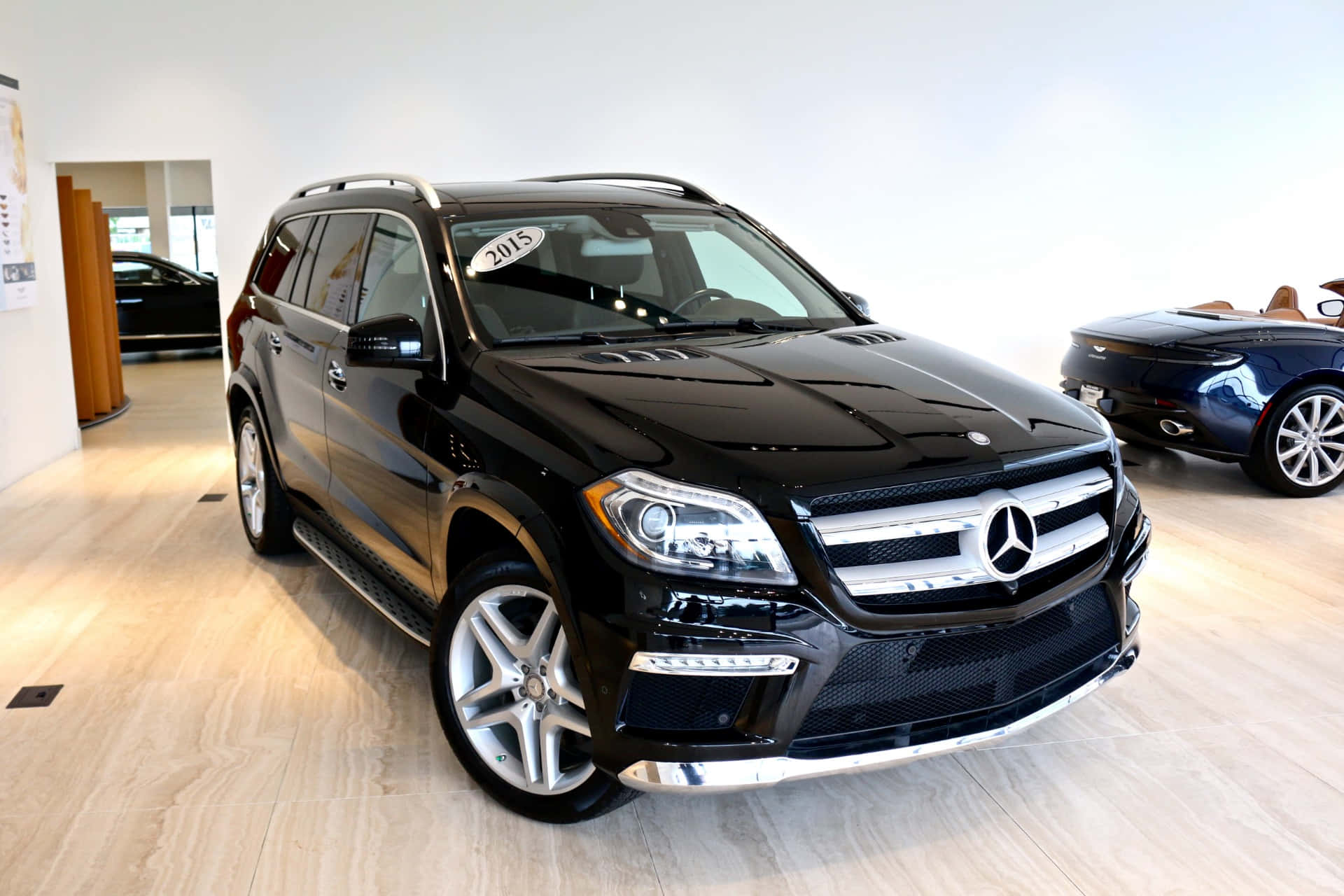 Mercedes-benz Gl-class 桌布 壁紙 — 一輛光亮的黑色賓士GL-Class SUV在展廳燈光下閃耀，配備鍍鉻飾件和合金輪圈。