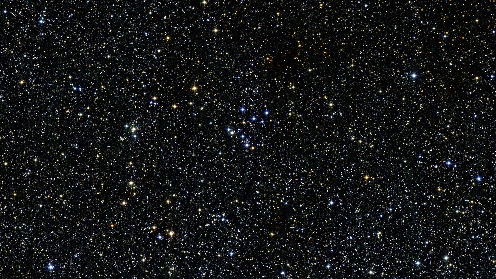  壁紙 — 一片密密麻麻的星場在深邃的黑色宇宙畫布上閃爍，散佈著藍色和黃色的光點。