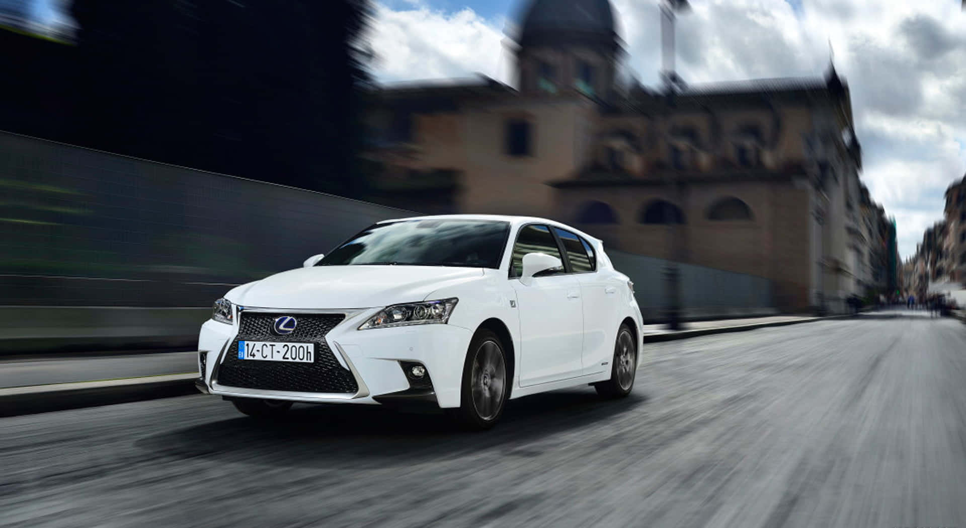 Lexus Ct 200h 桌布 壁紙 — 一輛白色Lexus CT 200h在歐洲街道上疾馳，歷史建築因運動而模糊。