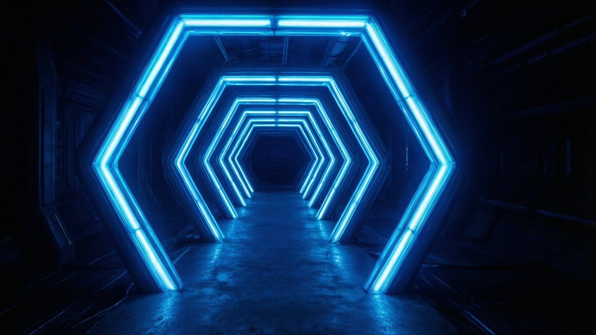 Neon Hex Tunnel 壁紙 — 一條黑暗的隧道，兩旁排列著發光的藍色六角形霓虹燈，向遠方延伸。