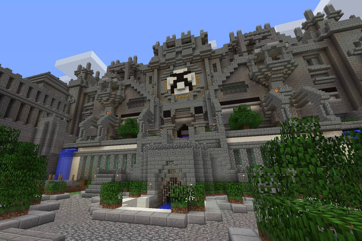 Minecraft城堡，有石牆和綠色灌木，在藍天下 — 可愛的 Minecraft 壁紙