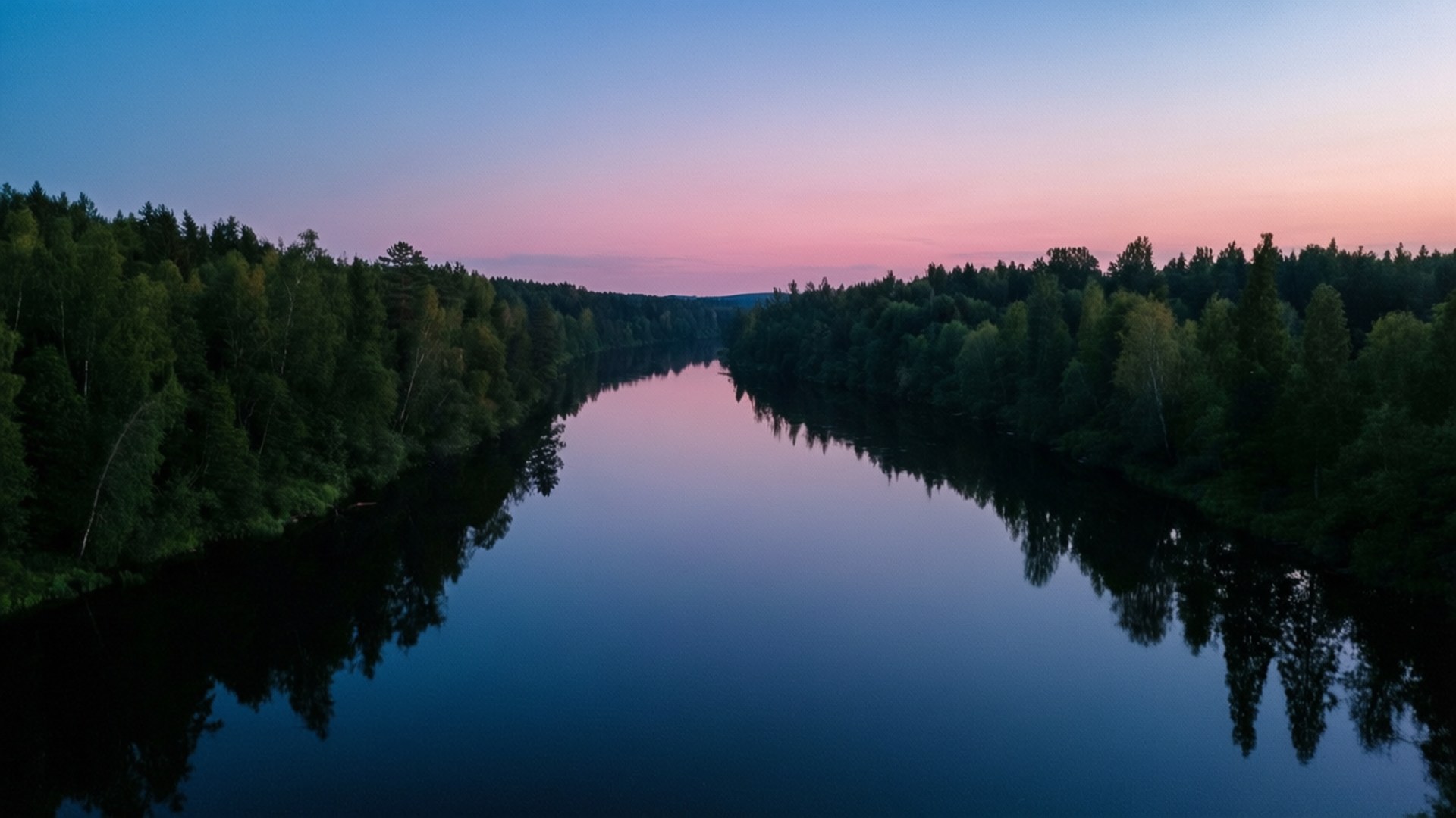 Forest River Twilight 壁紙 — 一條寧靜的河流映照著粉紅與藍色的暮色天空，蜿蜒穿過茂密的森林。