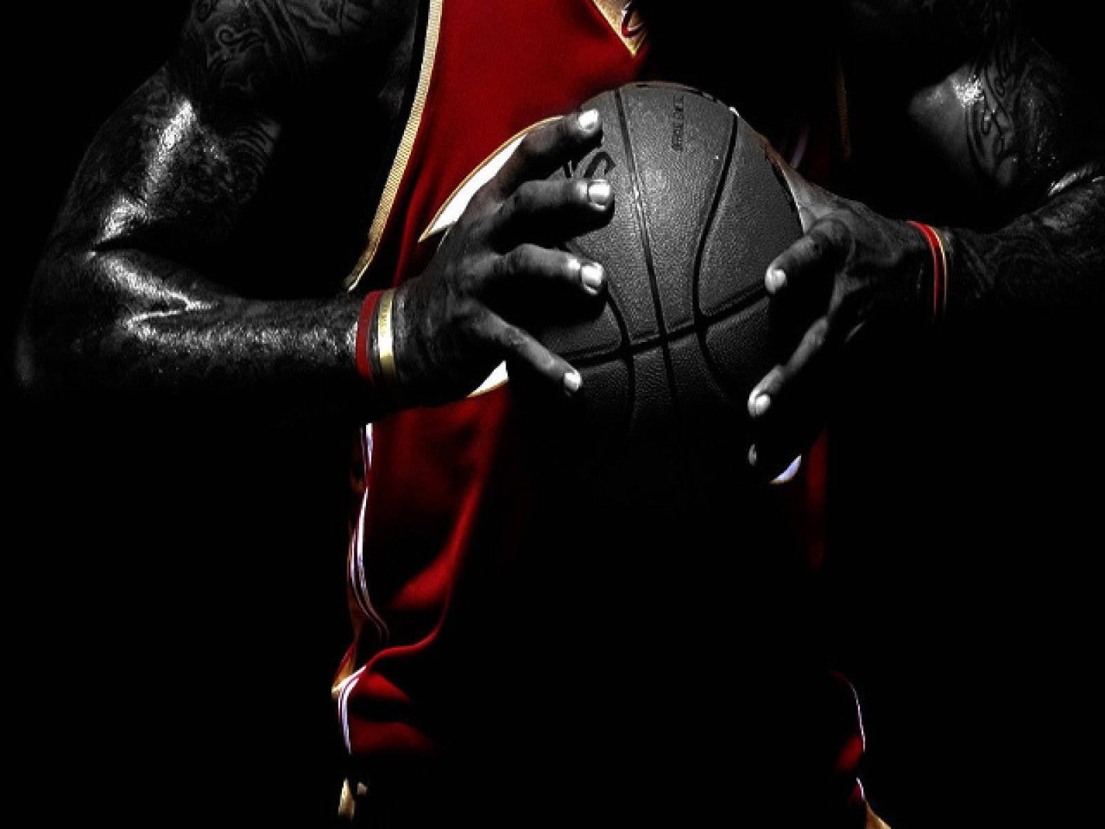 有刺青的籃球運動員在聚光燈下穿著紅色球衣持球。 — NBA 壁紙