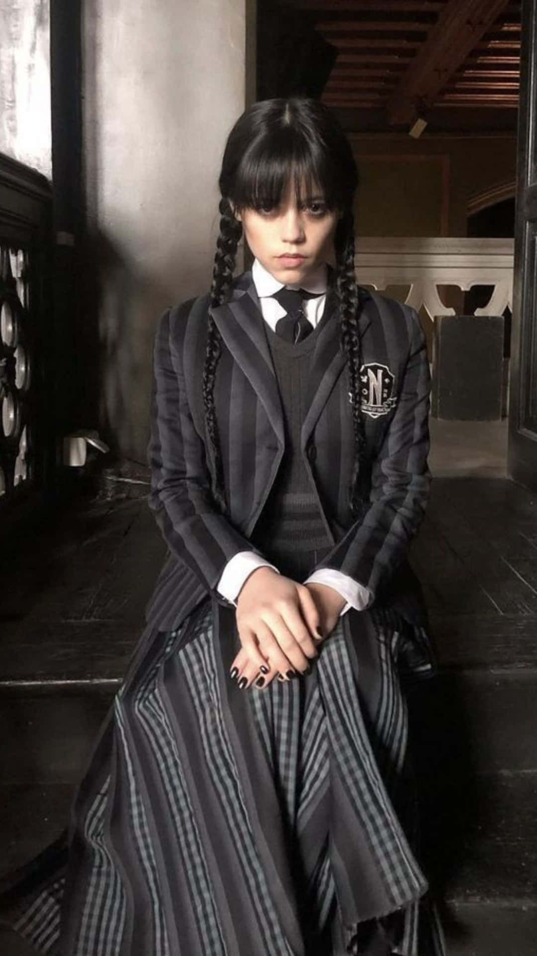  壁紙 — 一個紮辮的少女，穿著哥德式校服，嚴肅地坐在昏暗走廊的深色木樓梯上。