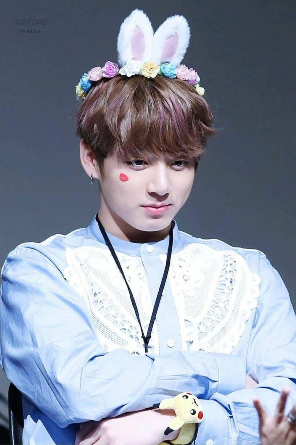 戴兔耳和花冠的年輕男子抱著皮卡丘絨毛玩具。 — Bts 壁紙