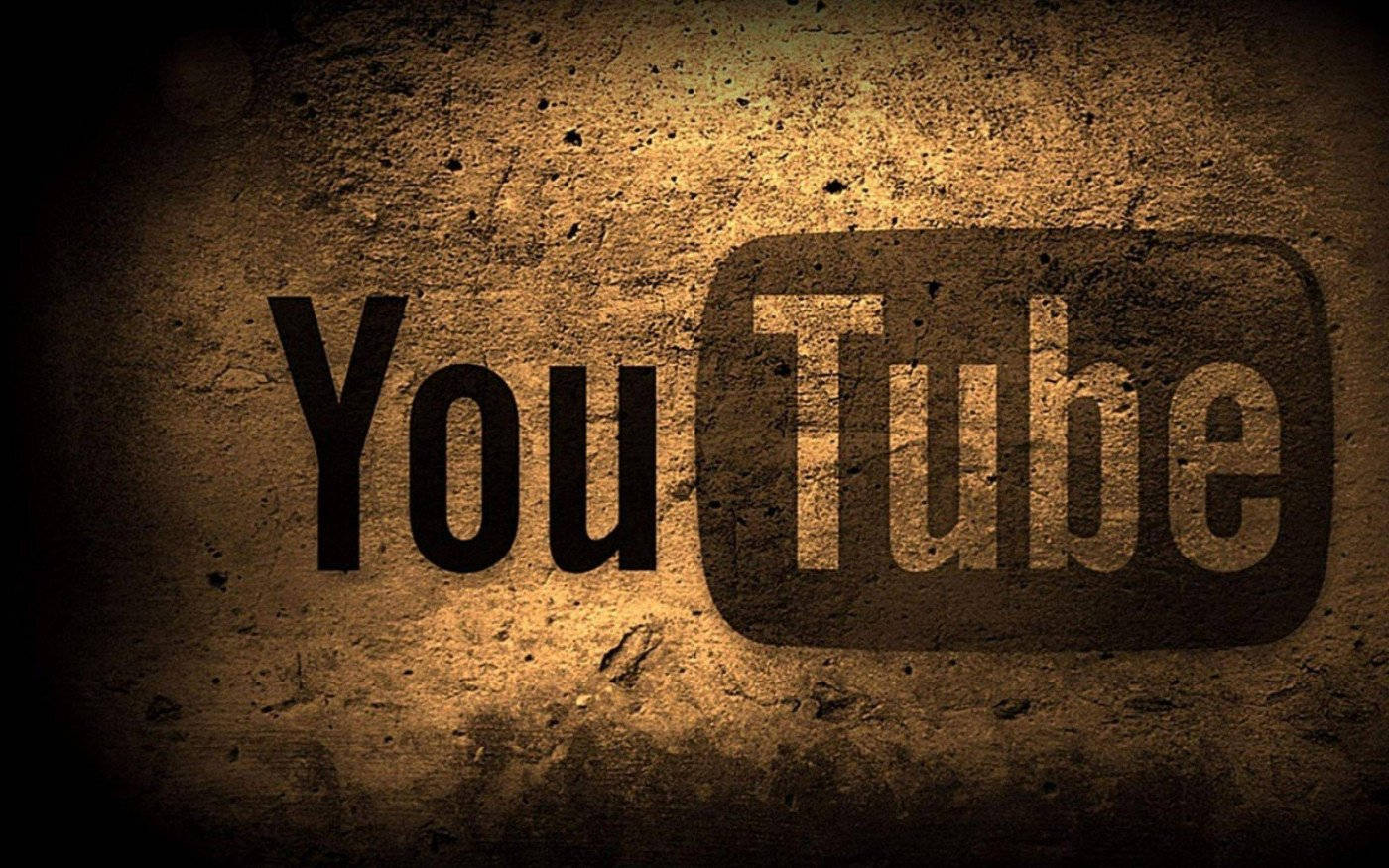 YouTube Logo 桌布 壁紙 — YouTube 標誌蝕刻在粗糙紋理的牆壁上，溫暖的聚光燈營造出粗獷的復古氛圍。