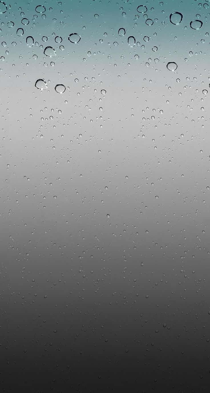  壁紙 — 雨滴依附在玻璃表面，漸變的天空從青綠色褪到炭灰色。