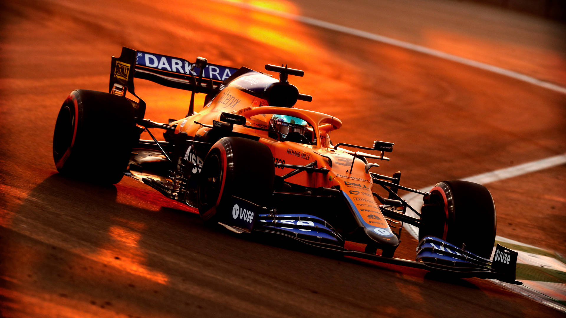 麥拉倫一級方程式賽車在日落時分於賽道上奔馳 — 酷炫F1 壁紙