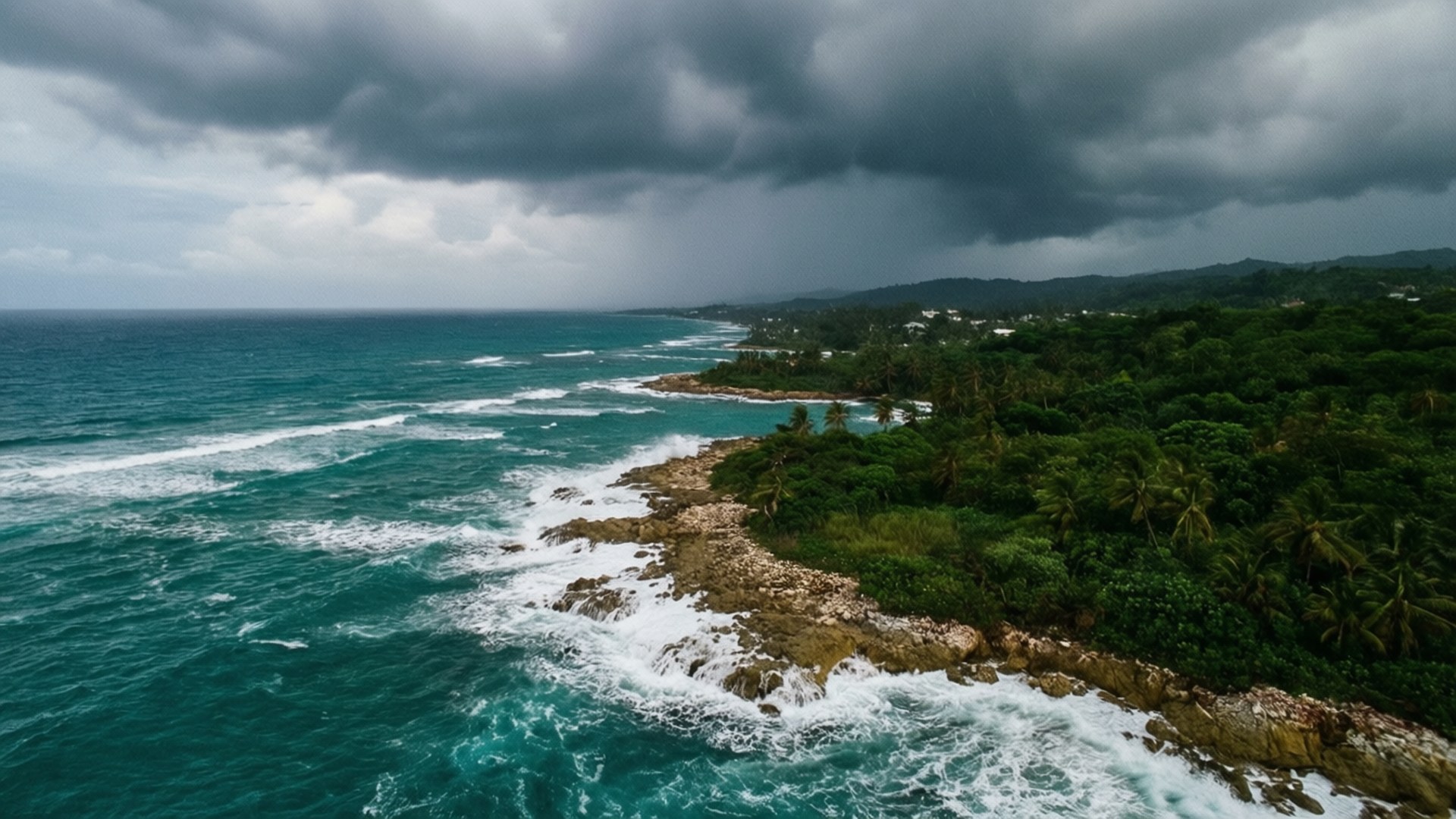 Dramatic Coastline View 壁紙 — 在黑暗風暴雲下，綠松石色的海洋拍打岩石海岸的鳥瞰圖。