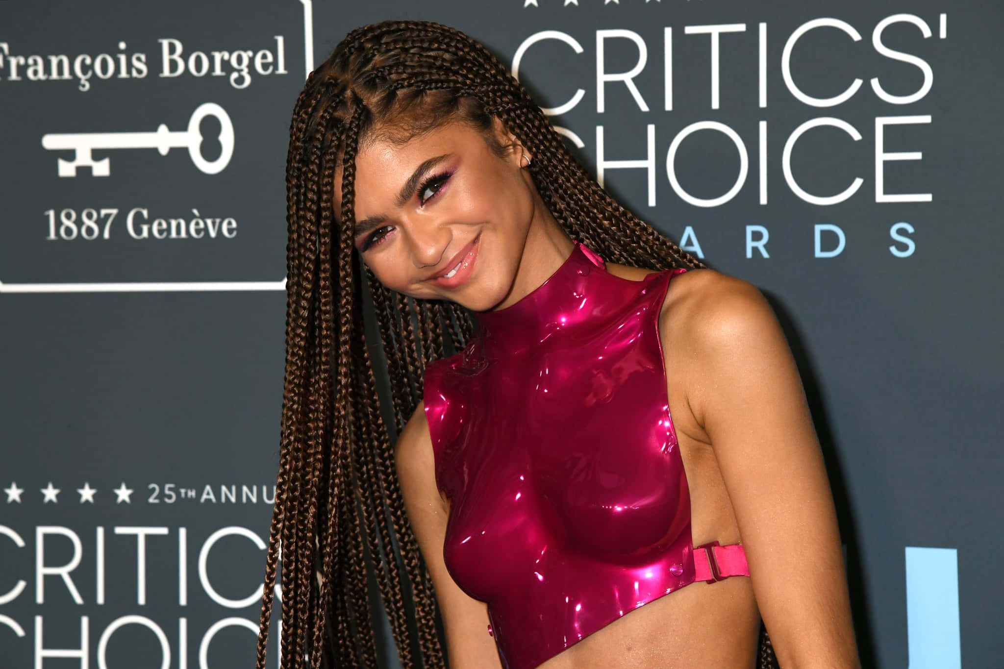 Box Braids Hairstyles 2021 桌布 壁紙 — Zendaya 在 Critics' Choice Awards 紅地毯上穿著閃亮的洋紅色露臍上衣，自信地微笑。
