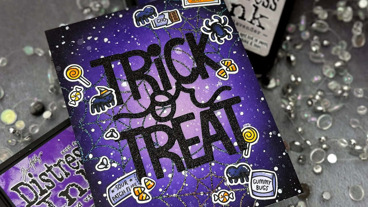  壁紙 — 一張閃亮紫色萬聖節卡片，以粗體黑色字寫著「Trick or Treat」，周圍環繞糖果貼紙和蜘蛛網細節。
