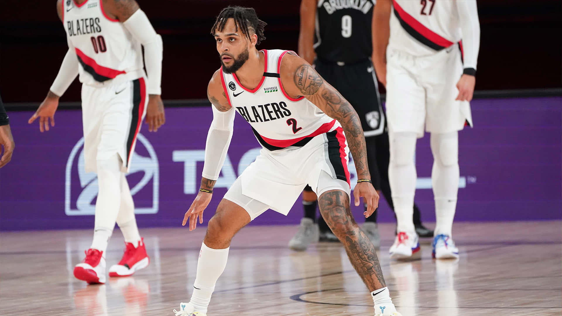身穿白色球衣的籃球運動員在比賽中蹲在球場上。 — NBA 壁紙