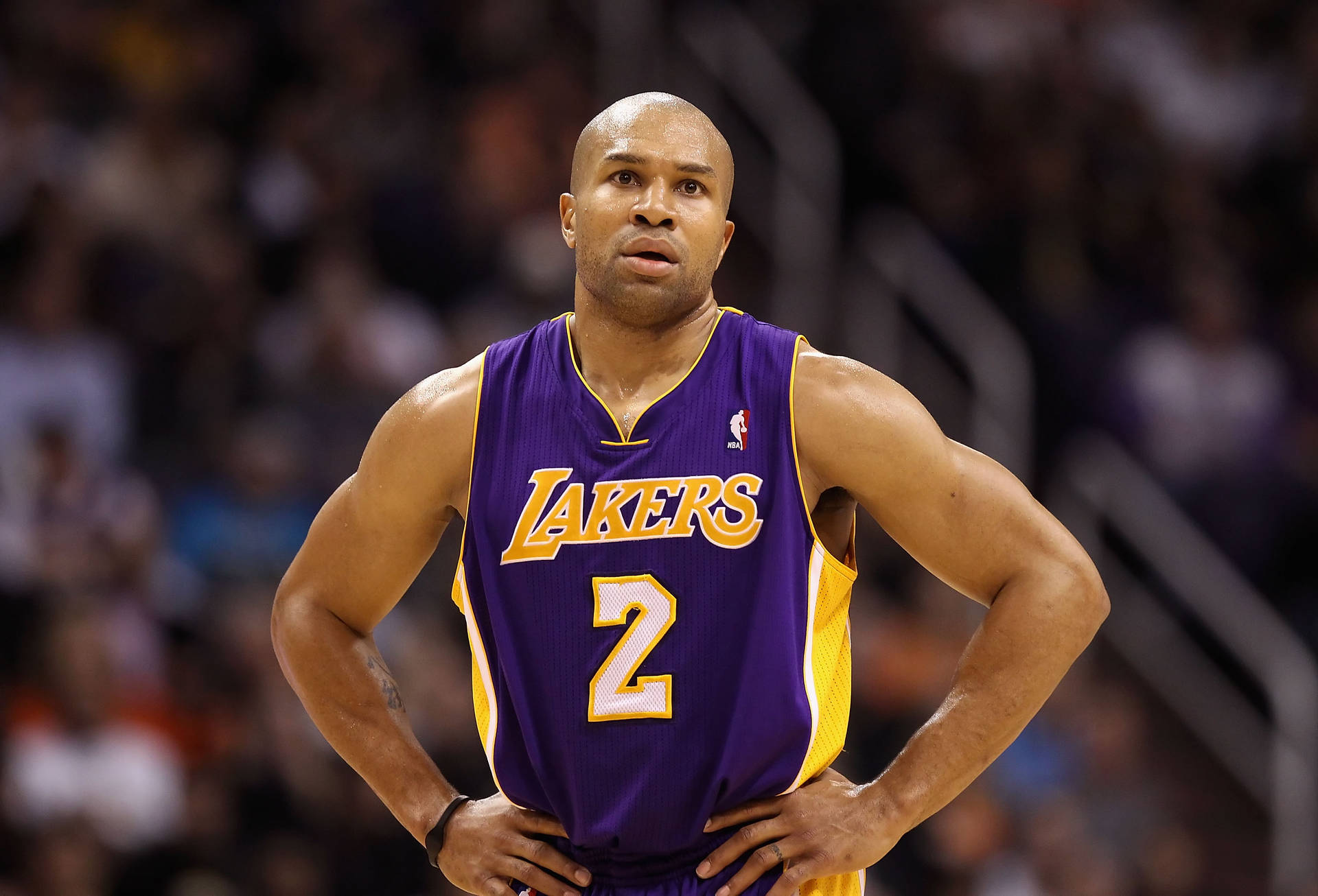 身穿湖人球衣的職業籃球運動員在球場上雙手叉腰站立。 — NBA 壁紙