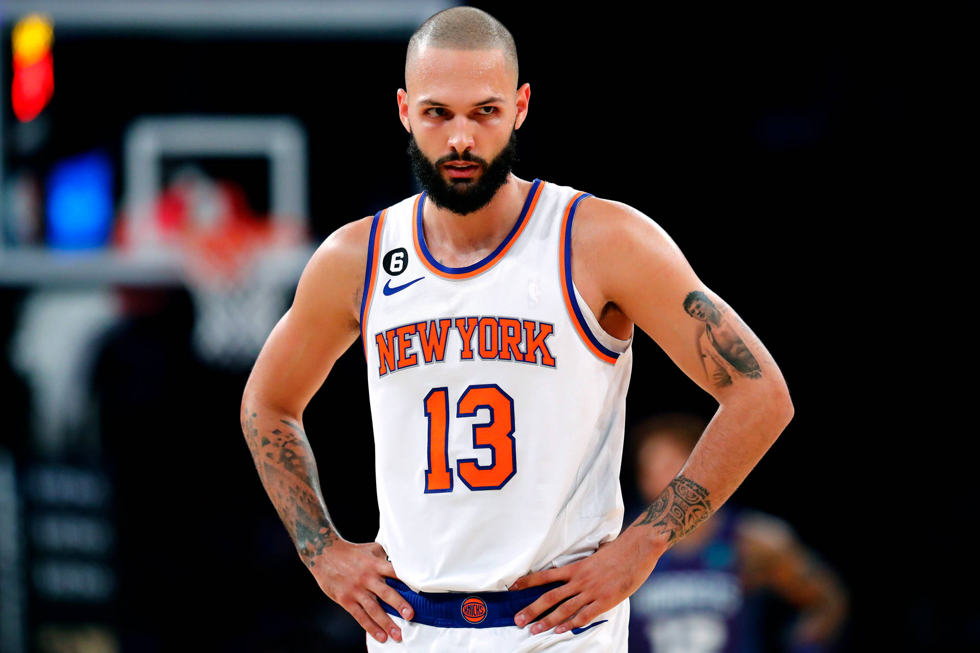 身穿紐約尼克隊球衣的籃球運動員站在球場上，雙手叉腰。 — NBA 壁紙