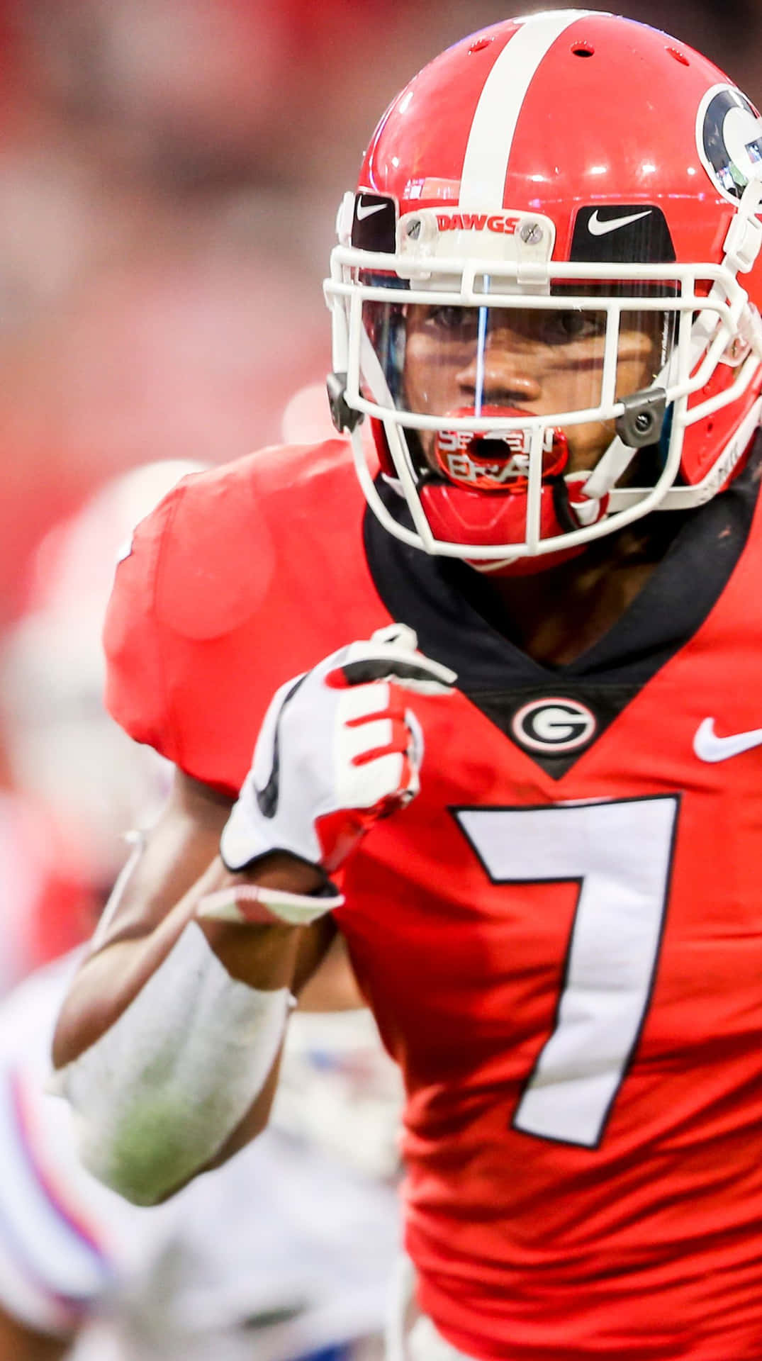  壁紙 — 一名專注的美式足球員身穿紅色Georgia Bulldogs球衣，號碼7，在比賽中向前衝刺。