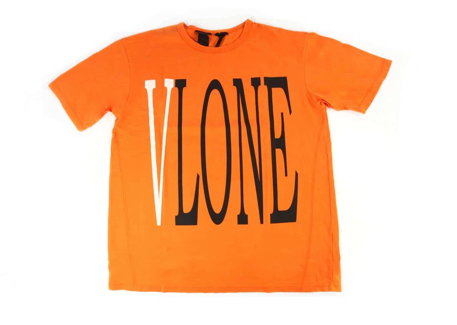 Vlone 桌布 壁紙 — 一件亮橙色T恤，上面有粗體黑白「VLONE」字樣，平放在白色背景上。