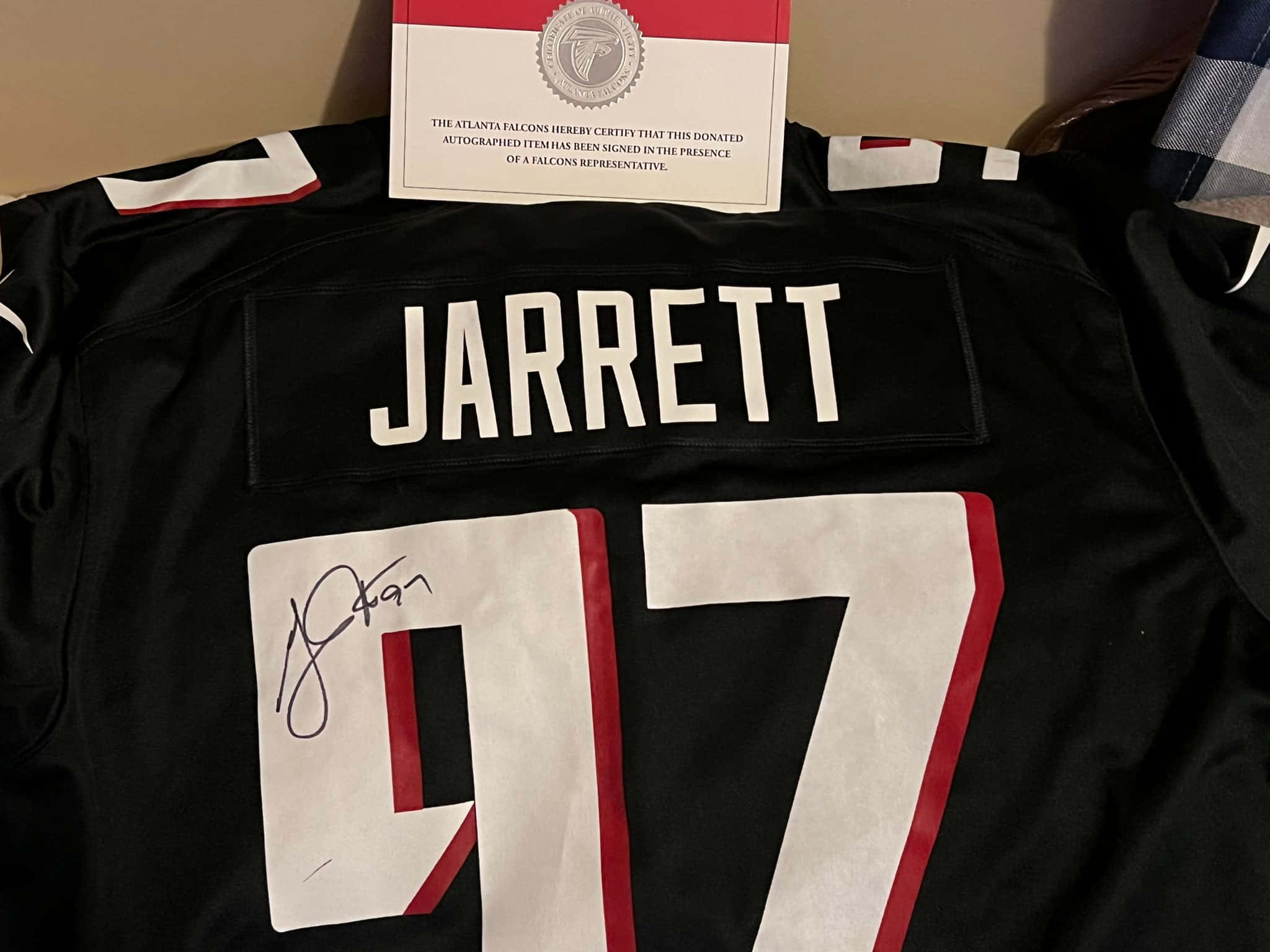 運動 桌布 壁紙 — 一件帶有 'JARRETT' 和 97 號的簽名黑色亞特蘭大獵鷹球衣，附有認證證書。