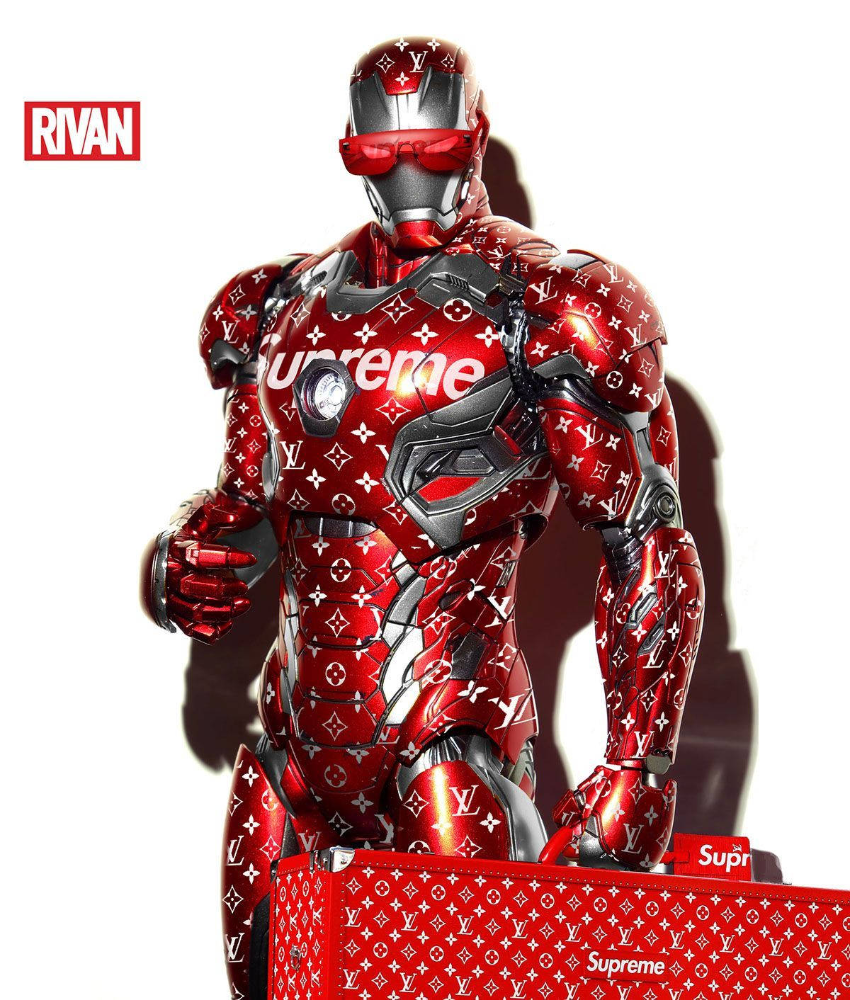 superhero supreme 桌布 壁紙 — 一件帶有光澤的紅色鋼鐵人戰衣，上面覆蓋著 Louis Vuitton 字母圖案和 Supreme 標誌，矗立在純白色背景前。