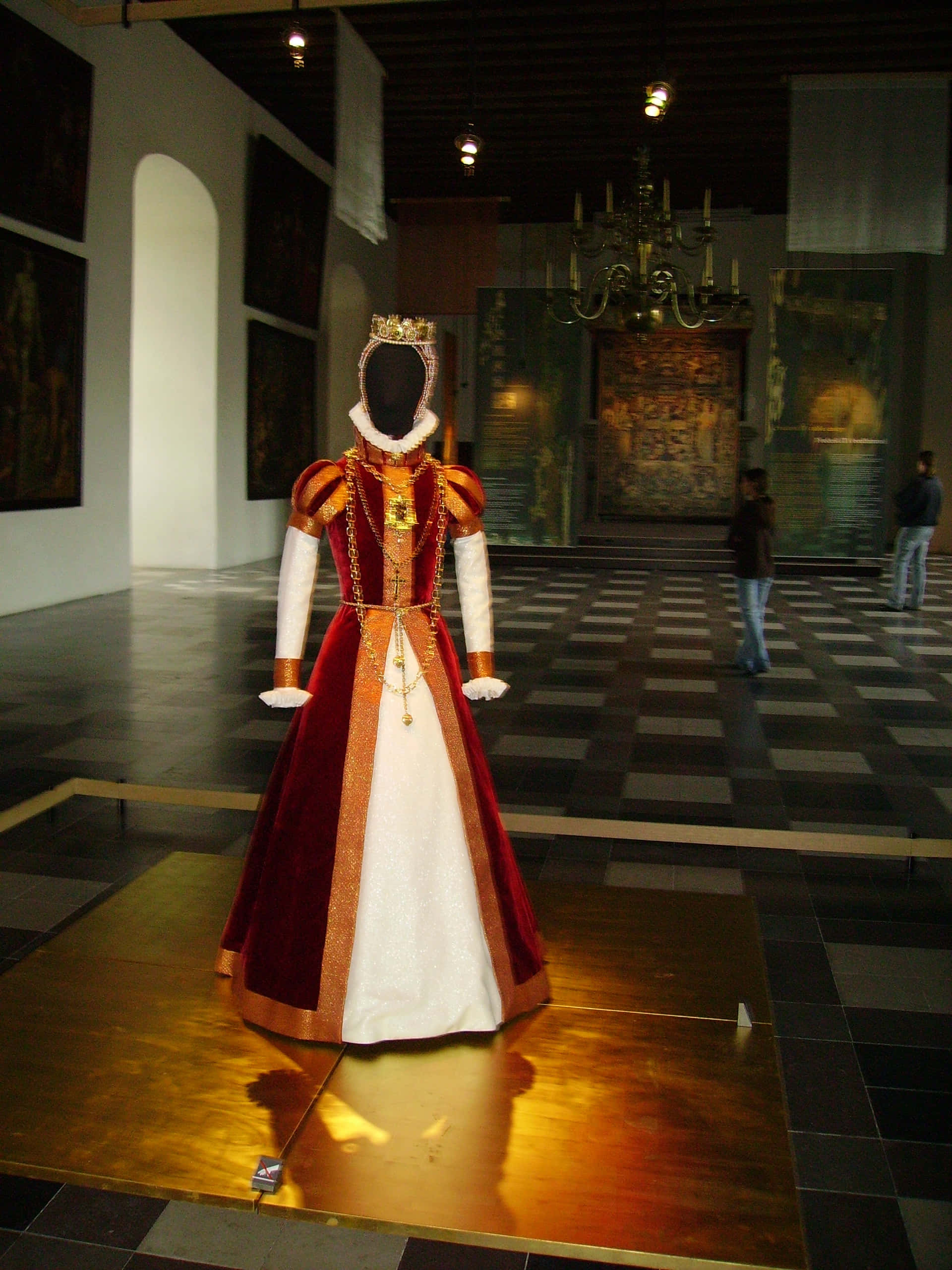 高清 桌布 壁紙 — 一件帶有王冠的紅白歷史皇家禮服，在燈光昏暗的博物館畫廊中的人體模型上展示。