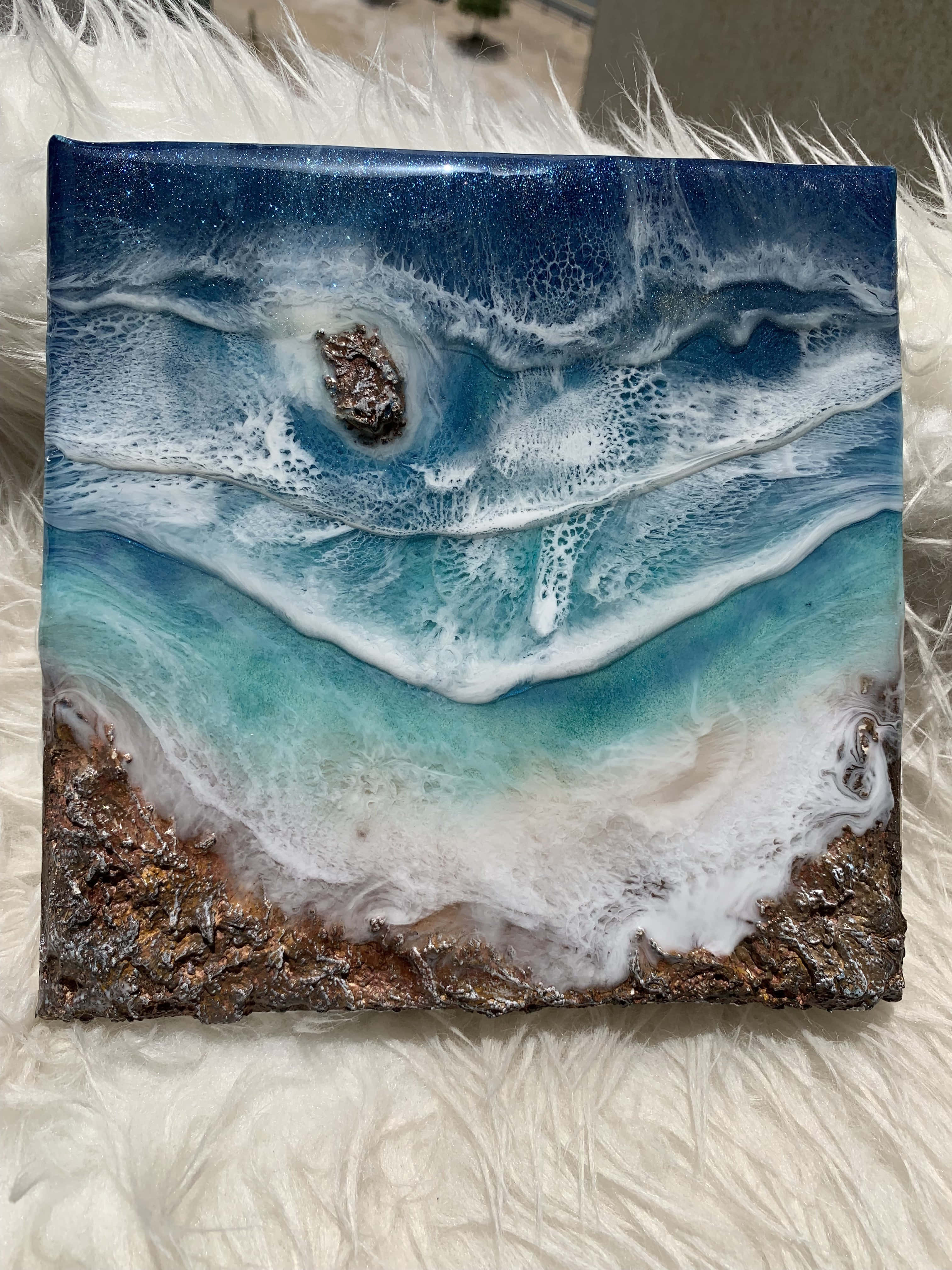 3d Ocean 桌布 壁紙 — 一件樹脂海洋波浪藝術品，上有藍色碧綠海水、白色泡沫和棕色岩石海岸，置於毛絨白色地毯上。