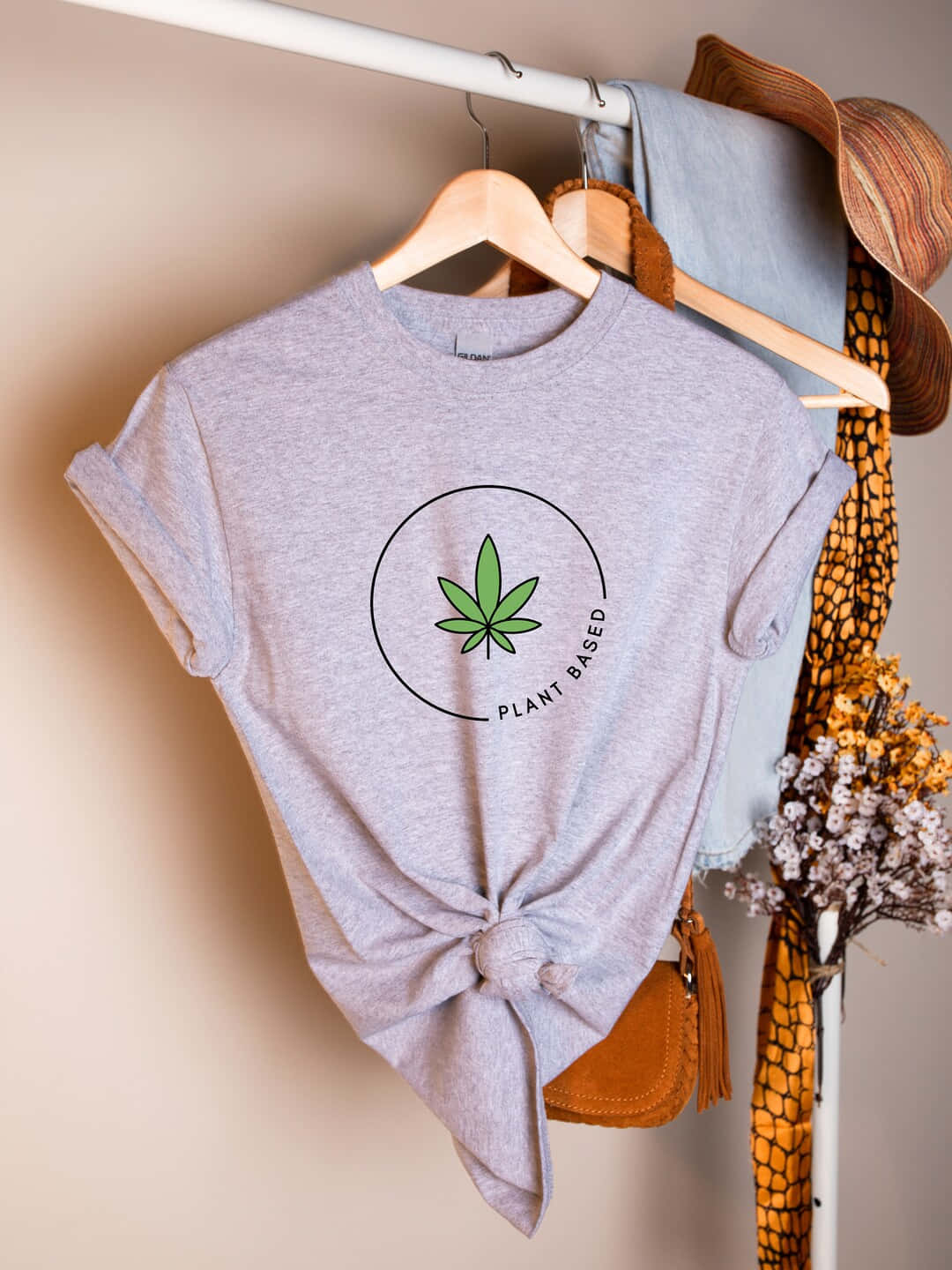 灰色植物性T恤打結掛在衣架上與配件一起 — 大麻 壁紙