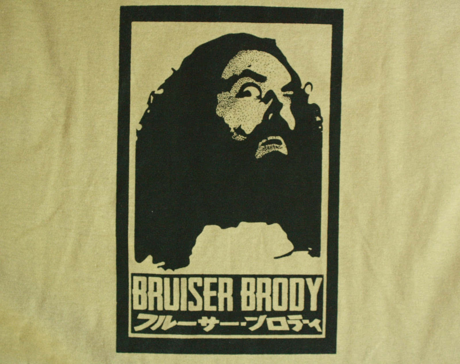 WWE 桌布 壁紙 — 一件米色T恤上印有Bruiser Brody的鮮明黑白絲印肖像，下方有日文字。