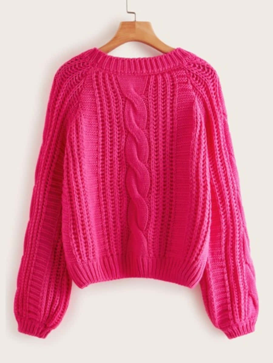 Pink Sweater 桌布 壁紙 — 一件鮮豔的紫紅色電纜針織毛衣掛在木衣架上，背景簡潔。