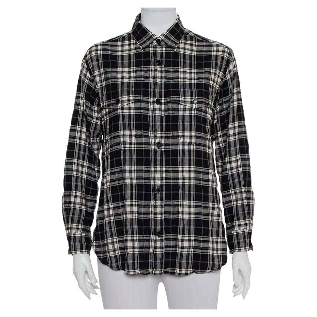 Burberry 桌布 壁紙 — 一件黑白格紋法蘭絨襯衫，前面有鈕扣和胸袋，展示在白色人體模型上，背景簡潔。