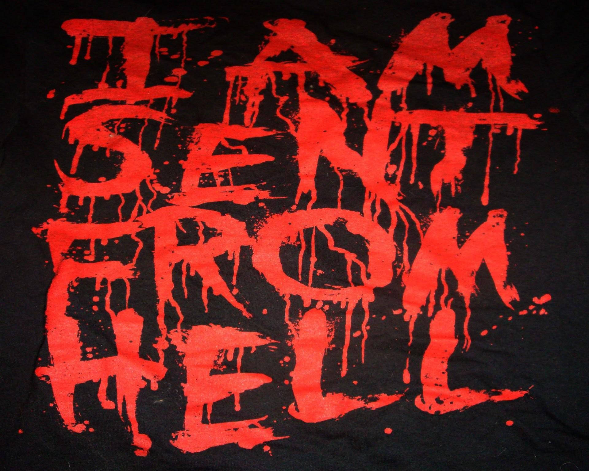 撒旦 桌布 壁紙 — 一件黑色T恤上印有粗體紅色滴落文字，寫著「I AM SENT FROM HELL」，採用混亂恐怖風格的字體。
