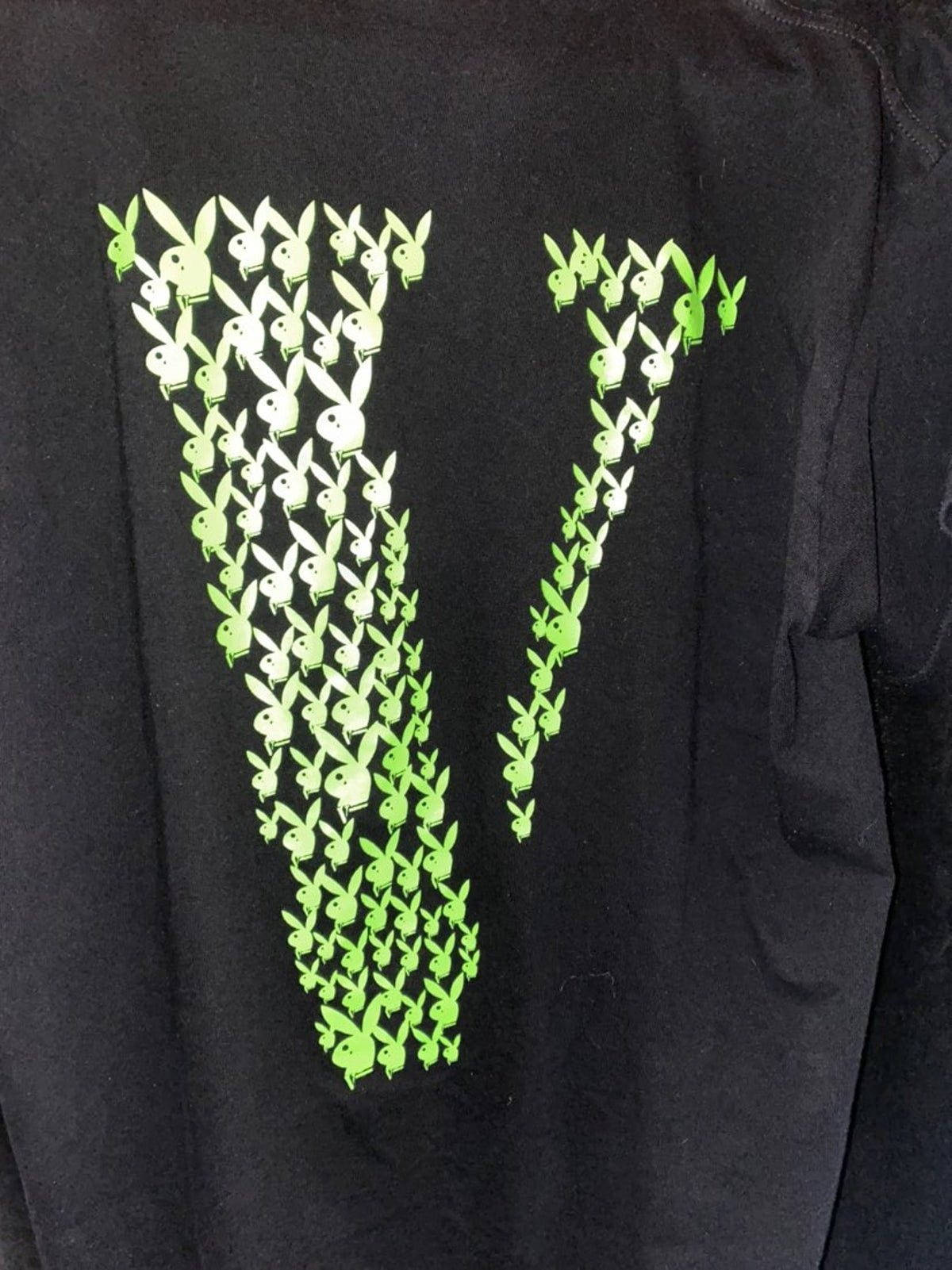Vlone 桌布 壁紙 — 一件黑色T恤上有一個由重複的Playboy兔子標誌以漸變色調組成的大型綠色字母V。