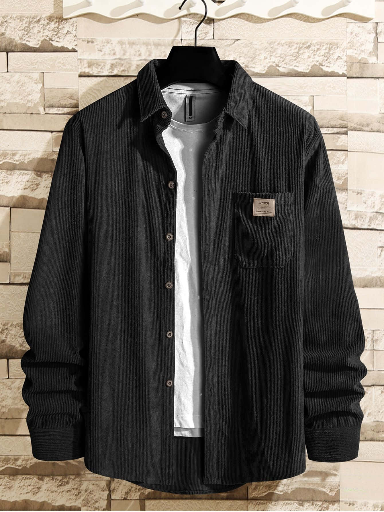 Black Clothing 桌布 壁紙 — 一件黑色燈芯絨襯衫，前面有鈕扣和胸袋，掛在衣架上，背景是紋理石牆。