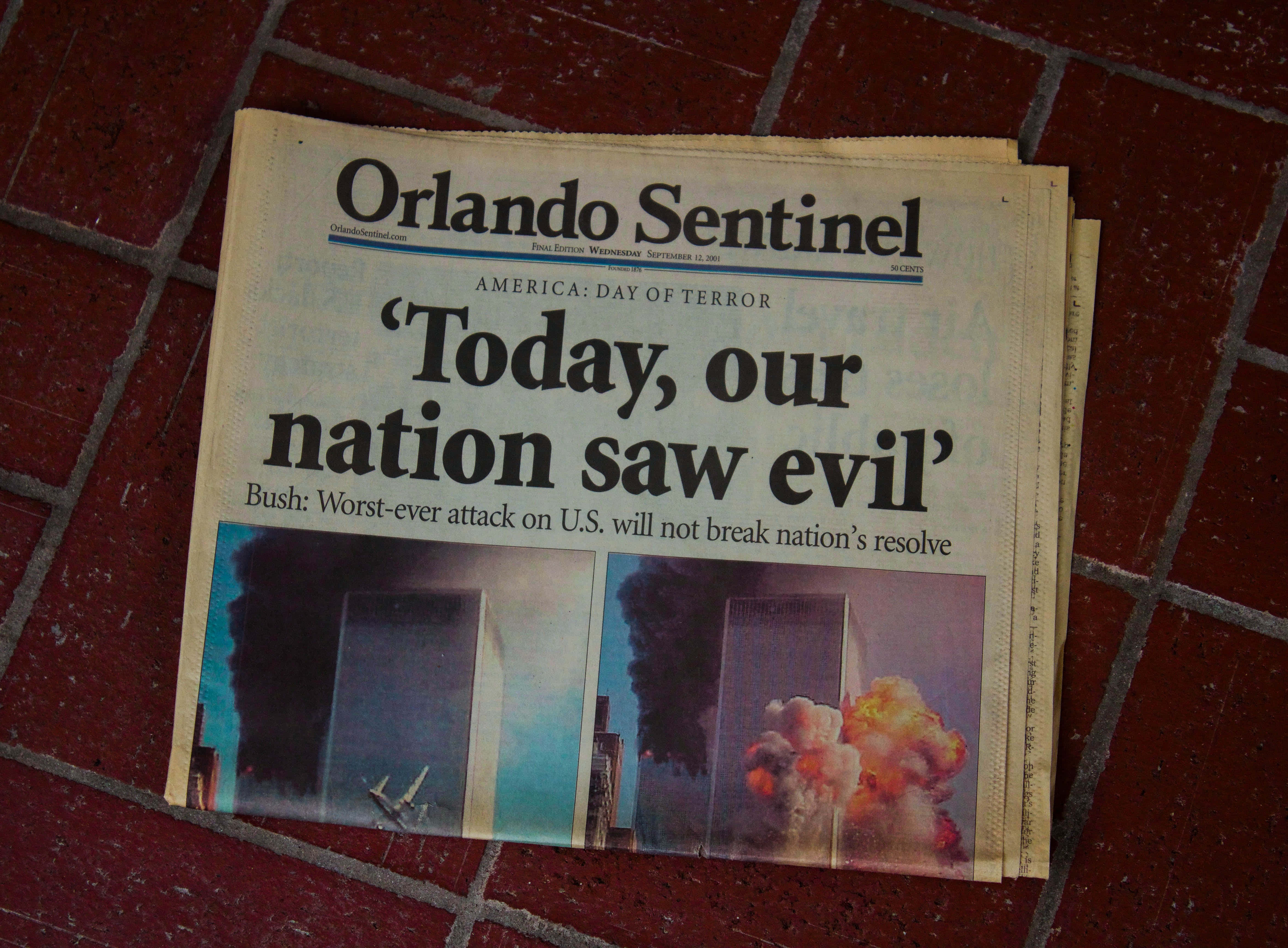 Old Newspaper 桌布 壁紙 — 一份折疊的《奧蘭多哨兵報》報紙，標題為「Today our nation saw evil」，放在紅色瓷磚地板上。