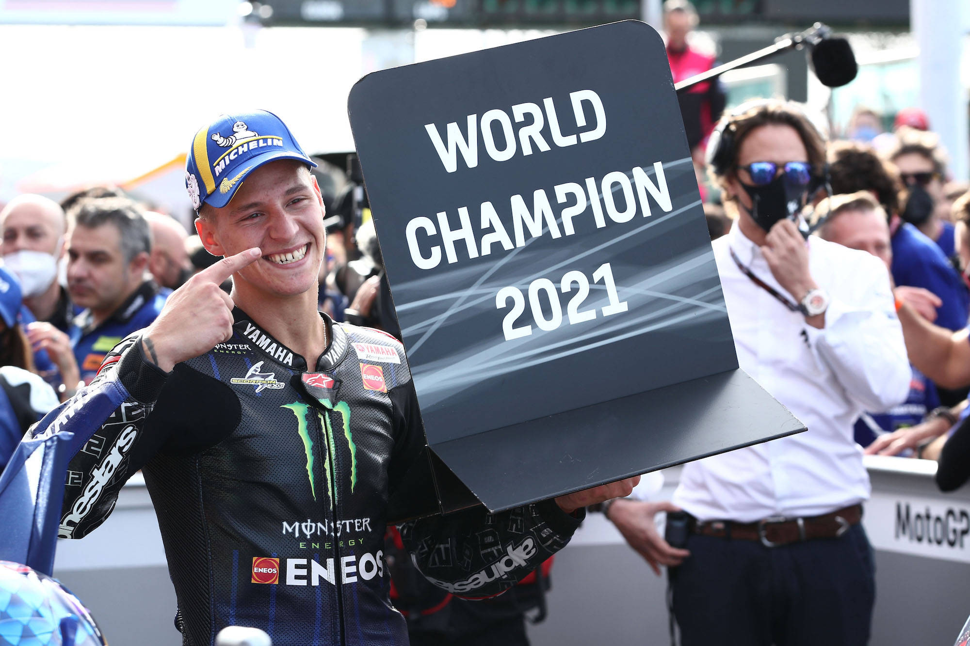 Champion 桌布 壁紙 — 一位MotoGP車手自豪地舉著「World Champion 2021」標誌，同時指著自己的臉。